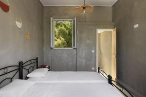 a bedroom with a large bed with a window at Mazi in Sifnos in Sifnos +10 photos
