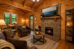 a living room with a fireplace in a log cabin at Tennessee Whisper Cabin in Sevierville