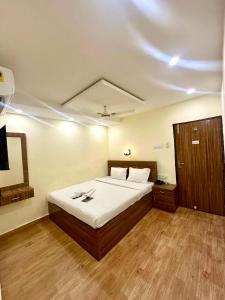a bedroom with a large bed with white sheets at Hotel Tu Casa in Kolkata