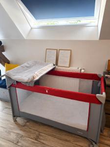 a red and white bed in a room with a window at La Manch'hôtes in Domjean
