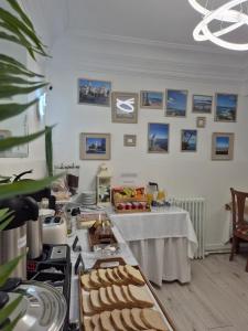 a kitchen with a table with food and pictures on the wall at Hostal La Mexicana in Santander