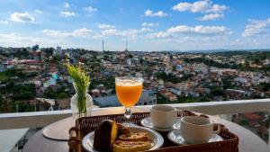 a table with a glass of orange juice and bread and coffee at Pousada Vista Chic in Cunha