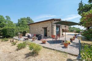 a stone patio with a table and an umbrella at Nerbone Farm Retreat in Perugia