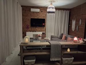 ein Wohnzimmer mit Sofa und Tisch in der Unterkunft L'échappée verte Appart entier sans coupure d'eau in Mtsamgamouji