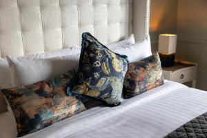 ein Bett mit drei Kissen darauf in der Unterkunft Tigh Mary Donals Bar & Rooms at Whitegates in Killarney + 25 Fotos