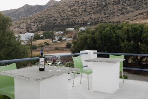 a bottle of wine sitting on a table with wine glasses at Mazi in Sifnos in Sifnos
