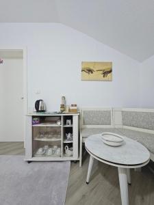 a living room with a table and a couch at Peja Riverside Hostel in Peje