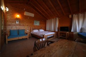 a bedroom with a bed and a table in a cabin at Aviv - Bakfar in Amirim in Amirim