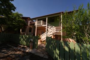a house with a green fence and a porch at Aviv - Bakfar in Amirim in Amirim
