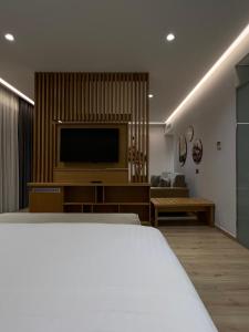 a bedroom with a bed and a flat screen tv at El Primero Hotel in Sarandë