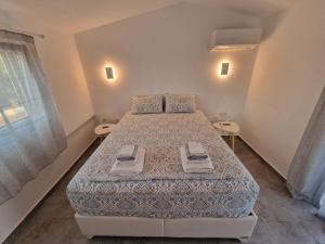 a bedroom with a bed with two towels on it at Sea & Olive Retreat in Zipárion