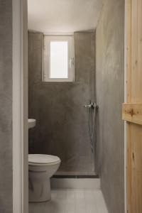 a bathroom with a toilet and a window at Mazi in Sifnos in Sifnos