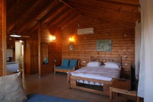 a bedroom with a bed in a wooden cabin at Aviv - Bakfar in Amirim in Amirim