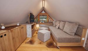a living room with a couch in the attic at Goldhorn Chalet SKI IN&OUT in Kranjska Gora