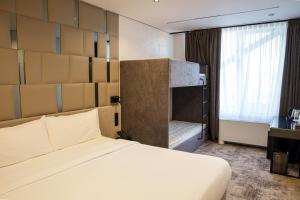 a hotel room with a bed and a window at Mildom Residence in Almaty +55 photos