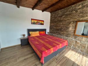 a bedroom with a bed and a stone wall at Villa Oliva Torotto in Niscemi +39 photos
