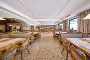a dining room with wooden tables and benches at Hotel Bärenbachhof in Saalbach-Hinterglemm