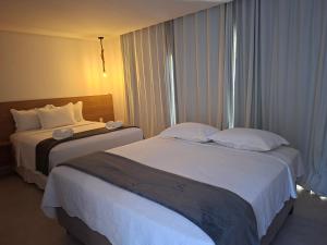 a hotel room with two beds and a window at Hotel Maragogi Beach Club in Maragogi +42 photos