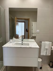 a white bathroom with a sink and a mirror at Perola Mar in Nazaré +19 photos