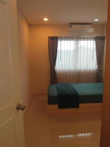 a bedroom with a bed and a window with curtains at Sunset Groove Cafe in Nong Prue