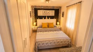 a bedroom with a bed with yellow pillows at Vejer de la Frontera Luis in Vejer de la Frontera