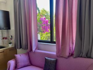 a pink couch sitting in front of a window at Villa Sofia in Chrani