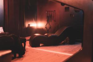 a woman sitting on a chair in a room at La Maison Coquine Love Room Balnéo in Béthune