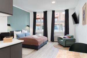 a bedroom with a bed and a couch and a chair at nestup - Hildesheim Zentral in Hildesheim +28 photos