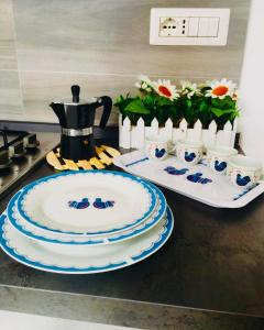 a kitchen counter with plates and a coffee pot and flowers at Il Quarzo A) B) in Càbras +19 photos