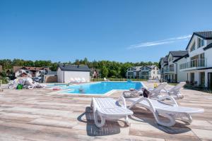 a swimming pool with lounge chairs next to a pool at Łebska Osada- basen, parking in Żarnowska