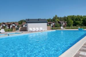 a swimming pool with chairs in front of a building at Łebska Osada- basen, parking in Żarnowska +7 photos