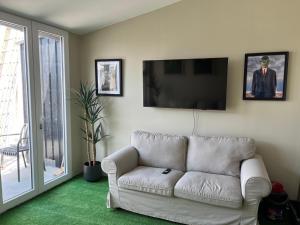 a living room with a white couch and a flat screen tv at Studio Magritte 156 in Boussu