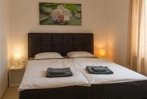 a bedroom with a large bed with two towels on it at Graf-Apartments-Vir-Zadar in Vir +129 photos