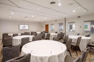 a conference room with tables and chairs and a screen at Coast Canmore Hotel & Conference Centre in Canmore