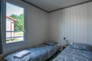 a bedroom with two beds and a window at Chalet Etxean in Hasparren