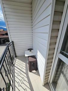 a small balcony with a table on the side at Cтаи за гости Бърдареви in Bansko