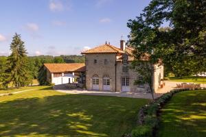 a large stone house with a large yard at Villa de La Roussie in Saint-Sulpice-de-Mareuil