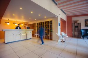a person standing at a counter in a lobby at King Tamar Hotel By Luxuria Hotels in Tbilisi City