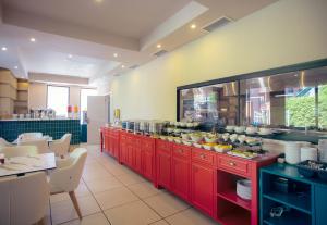 a large kitchen with red cabinets and a buffet at King Tamar Hotel By Luxuria Hotels in Tbilisi City