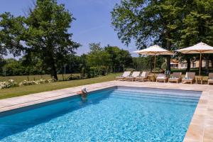 a woman is standing in the water in a swimming pool at Villa de La Roussie in Saint-Sulpice-de-Mareuil +21 photos