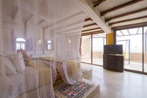 a bedroom with a bed covered in plastic at Kasbah Hotel Tombouctou in Merzouga