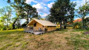 a small tent in a field with trees at Cool Under Canvas in Miremont