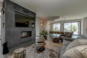 a living room with a large stone wall with a fireplace at Villa Casara Design and Relax Lago di Garda in Costermano