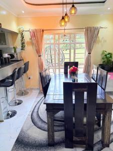 a dining room with a wooden table and chairs at OlTepesi HomeStay in Ololaimutiek
