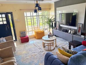 a living room with a blue couch and a tv at OlTepesi HomeStay in Ololaimutiek