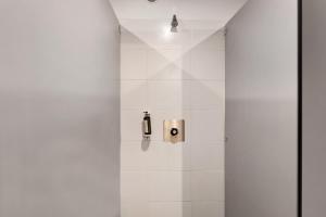 a bathroom with a shower with white tiles at Cabane Le Module in Angoisse