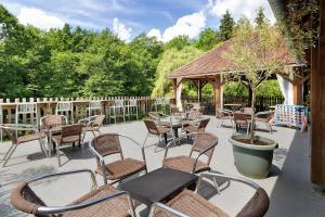 a patio with chairs and tables and a gazebo at Cabane Le Module in Angoisse