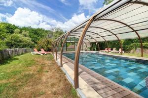 a large swimming pool with a retractable roof at Cabane Le Module in Angoisse