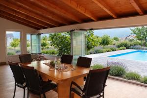 a dining room with a table and chairs and a pool at Villa Nirvana in Mostar