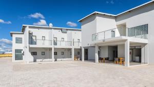 a large white building with a patio in front of it at Emirates Hotel in Ondangwa